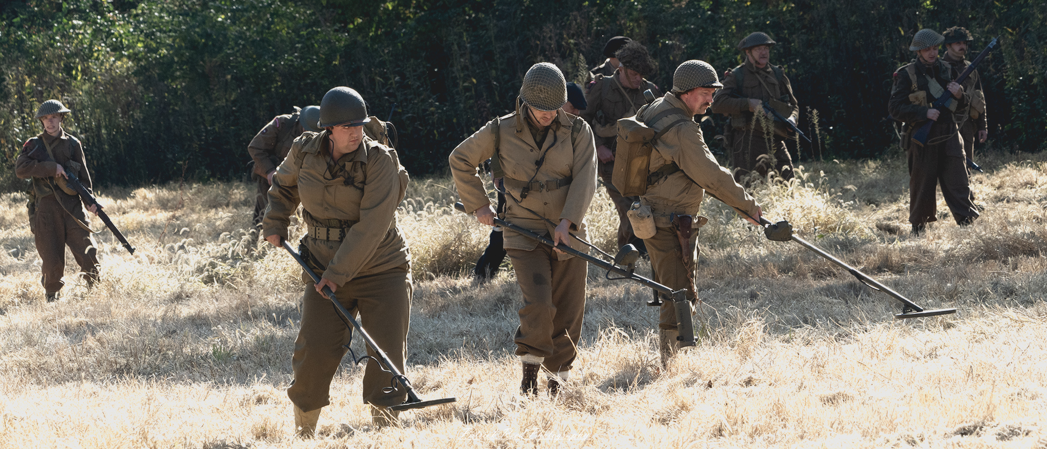 "Close-up image of World War II mine detectors, showcasing the intricate design and technology of these vital tools used in the field. The detectors, featuring metal probes and wooden handles, are placed against a backdrop of a sandy terrain, reminiscent of a battlefield or a minefield. The image highlights the historical significance of these devices in ensuring soldier safety and the efforts made to clear paths during combat. The focus on the detectors captures the ingenuity and resourcefulness of wartime technology, emphasizing the challenges faced by troops in navigating dangerous environments."